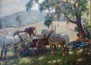 Leo Blake's "Lunch Break". Farmers and their horses rest under the shade of a tree. The horses are eating hay from a cart.