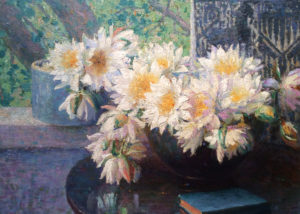 Mason's Still life with Daisies. A vase containing daisies on a table beside a blue book. An open window sits behind.